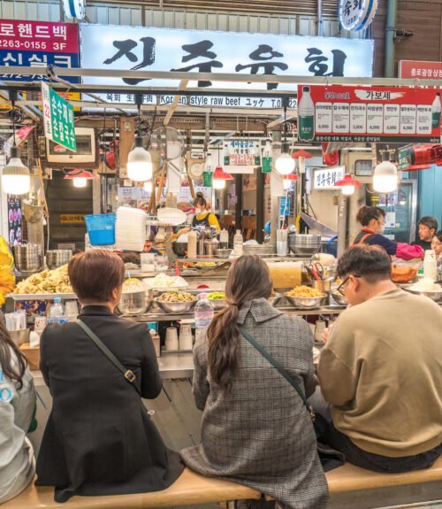 Seoul, South Korea - November 11, 2022 : shop and street food stall with many tourist at Gwangjang Market